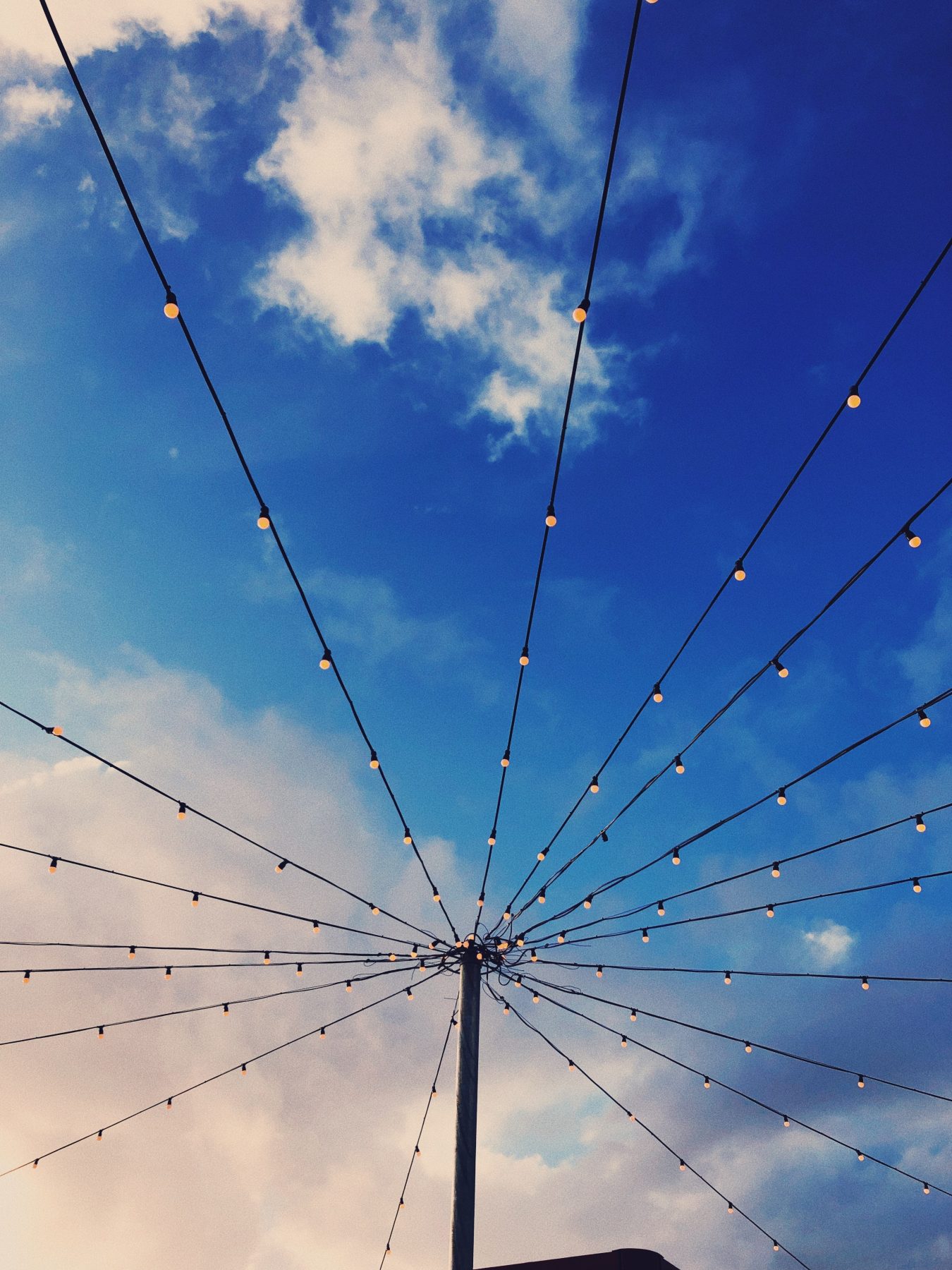 stringed lights extending from pole like spokes