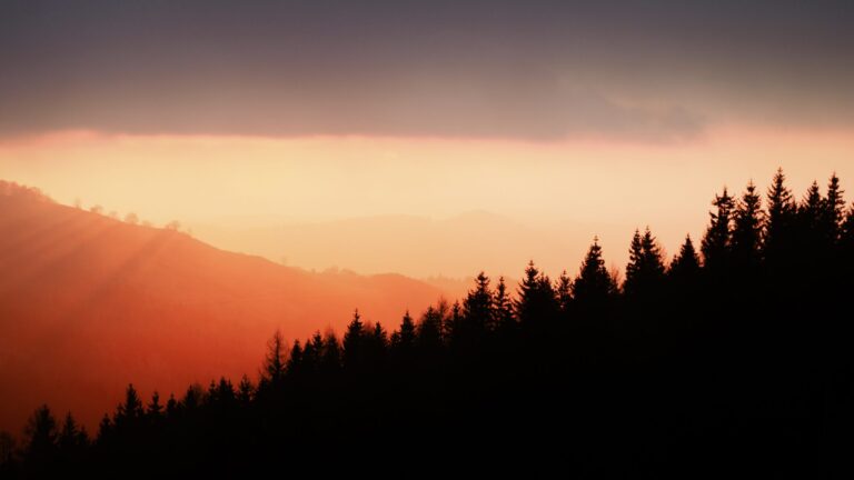 sun setting against mountains