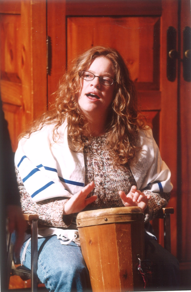 person drumming, wearing a tallit