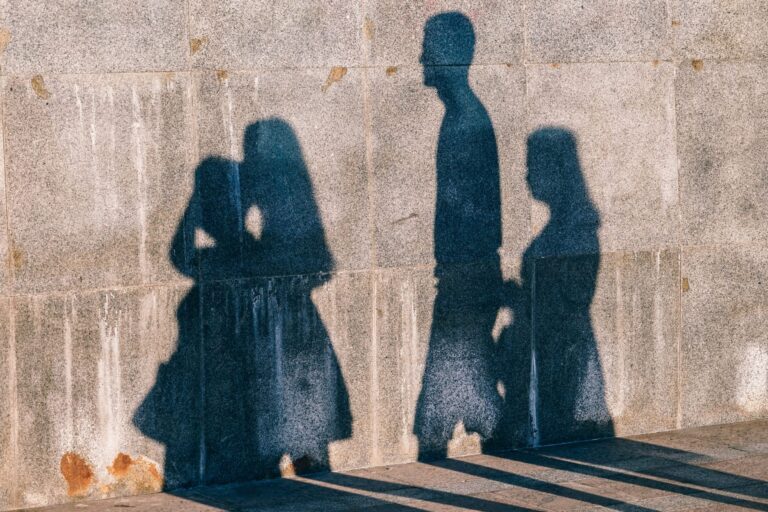 shadows of 4 people on a wall
