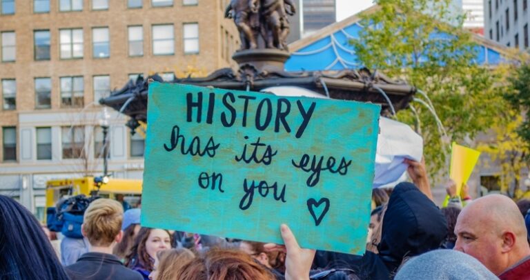 SIgn at demonstration reading "history has its eyes on you"