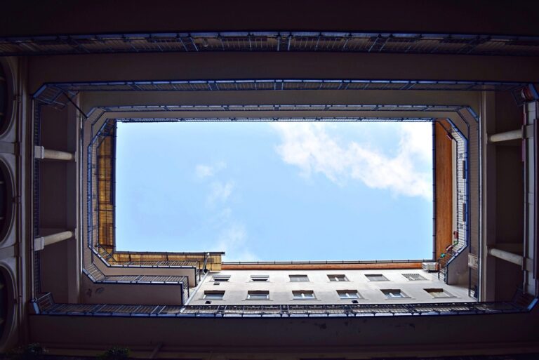 view of blue sky from below, between buildings