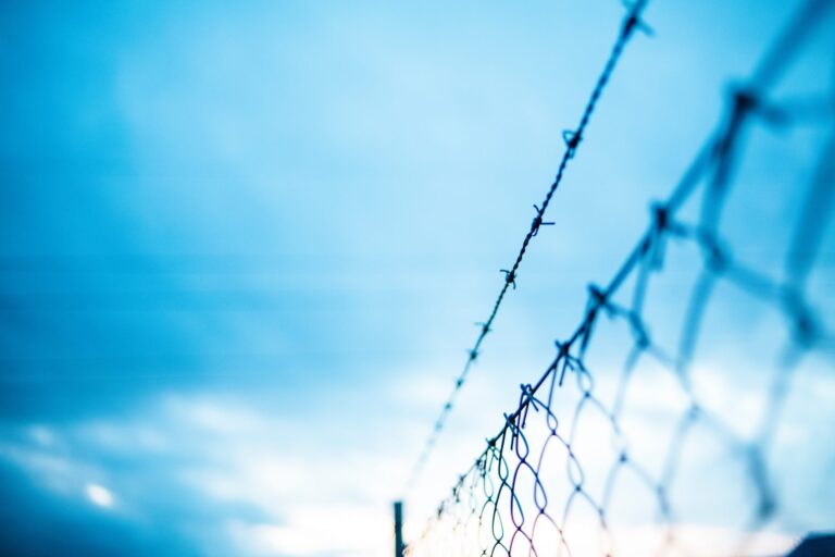 chain-link fence with barbed wire on top