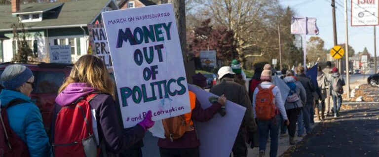 photo from March on Harrisburg, with marcher holding "Money out of politics" sign