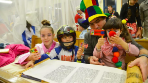 costumed kids and adult with open megillah