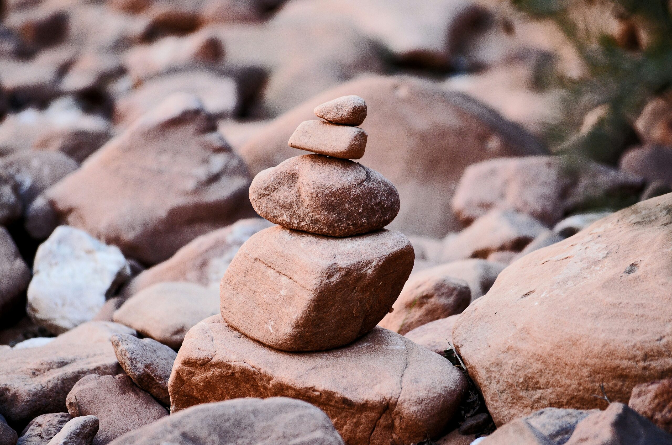 Stacked stones on a rocky surface, forming a balanced cairn in a natural setting.