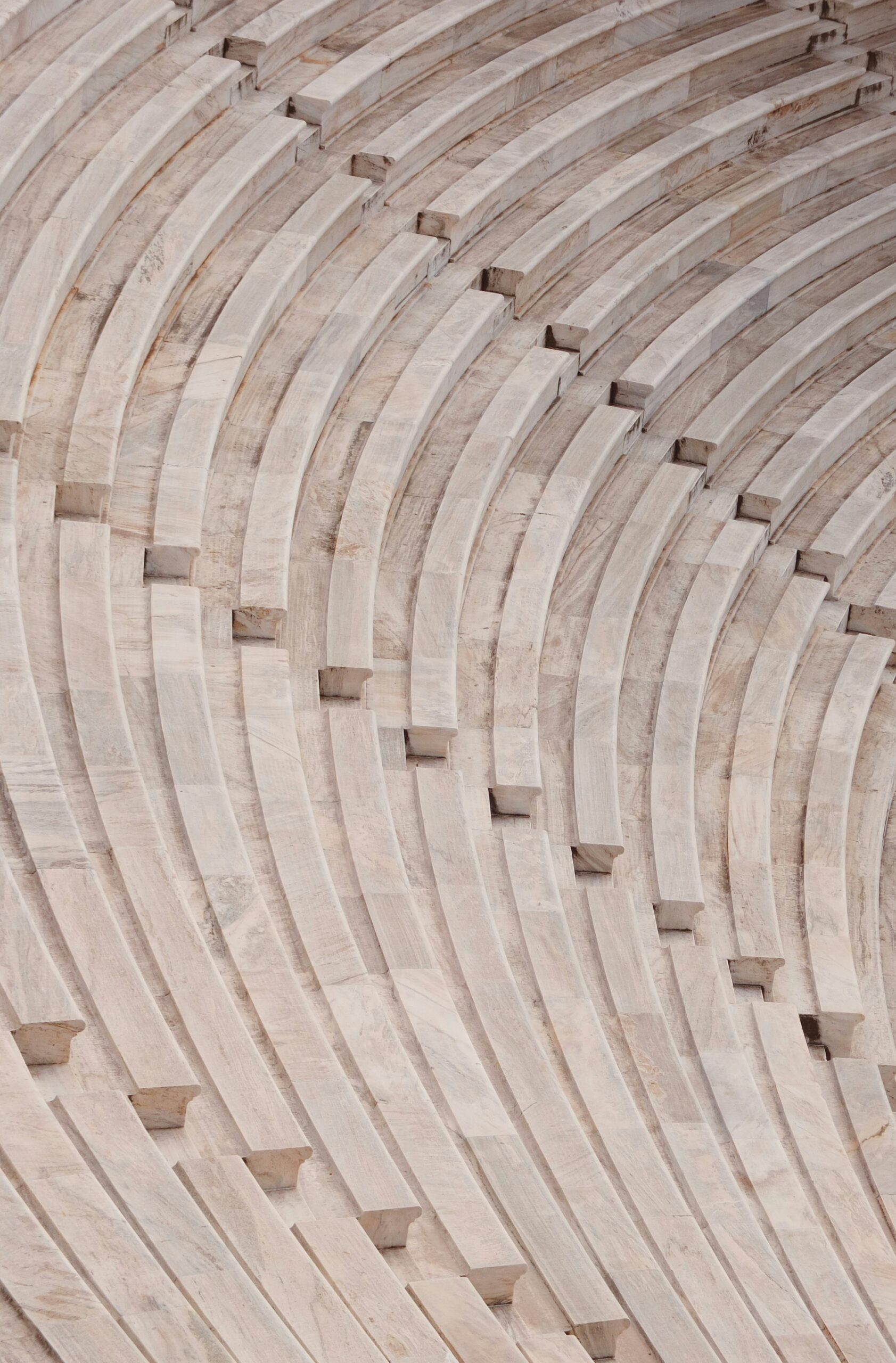 Close-up of curved stone steps in an amphitheater, showcasing repeating patterns and textures.