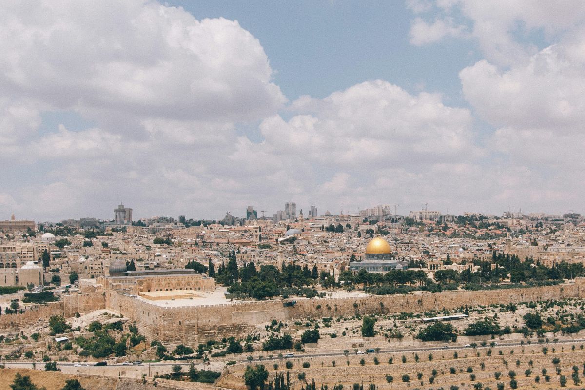 A panoramic view of the cityscape with a golden dome and historic buildings under a partly cloudy sky.