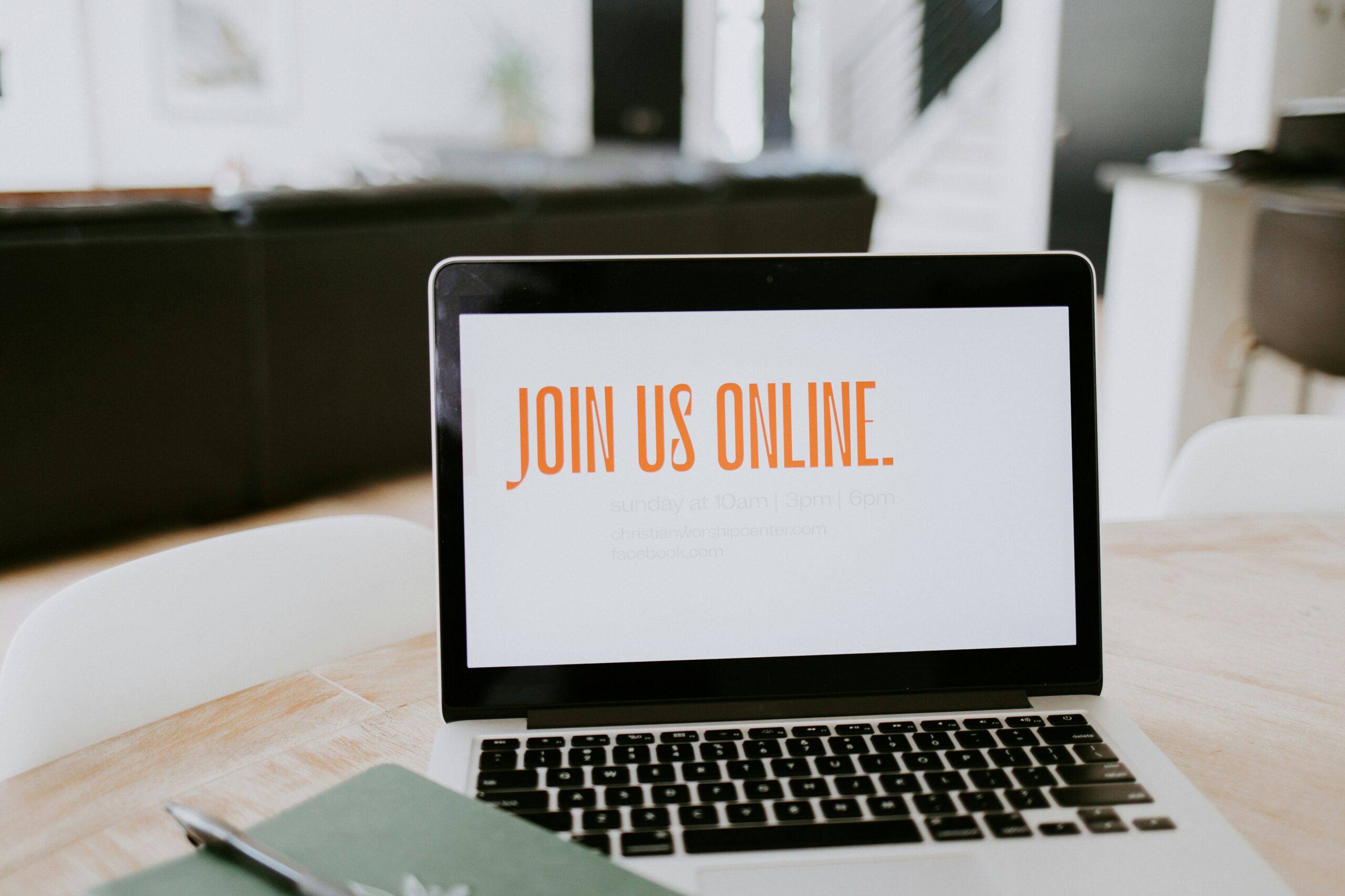 Laptop on a table with Join us online on the screen.