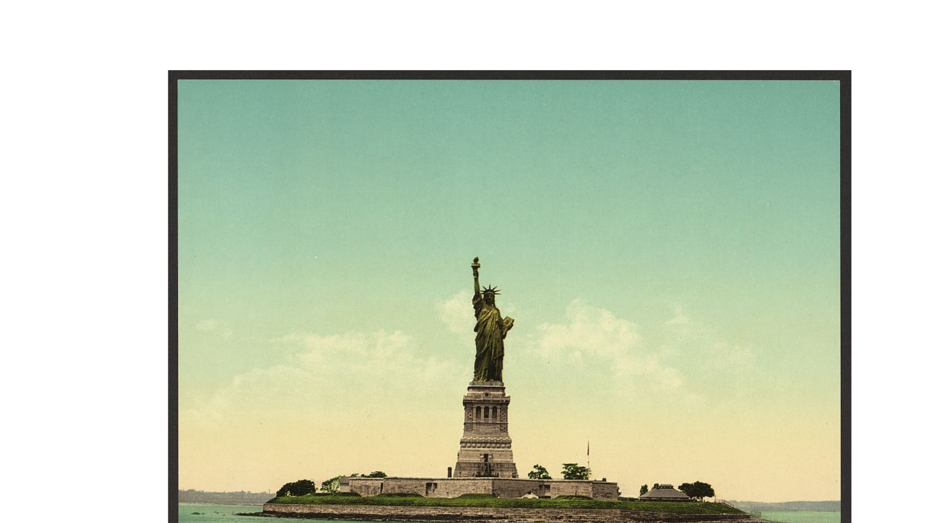 The Statue of Liberty stands on Liberty Island with blue sky and scattered clouds in the background.