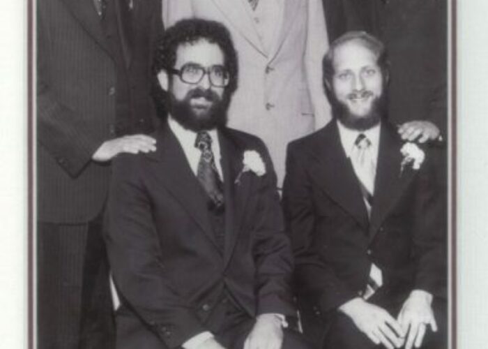 A group of five men in suits from the Class of 1977 posing for a formal graduation photo.