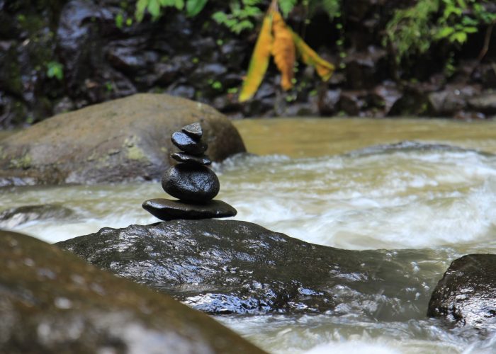 balancing pile of stones in rushing water
