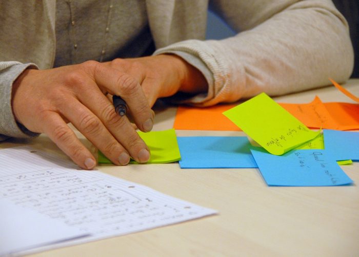 person's hands on table, with paper and post-its