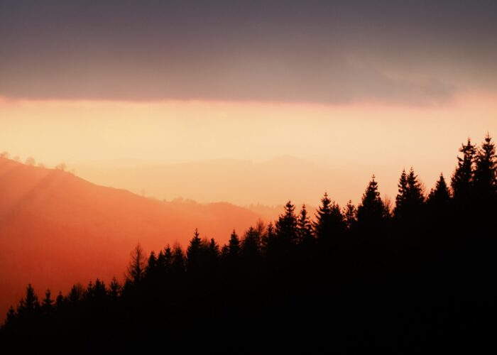 sun setting against mountains