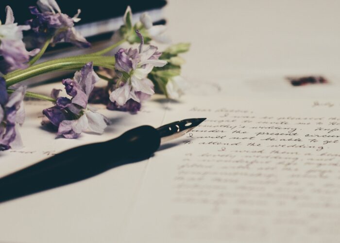 fountain pen and flowers on top of handwritten letter