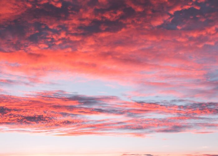 A sky filled with vibrant pink clouds during a colorful sunset.
