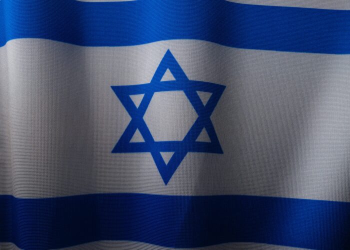 Close-up of the Israeli flag, displaying a blue Star of David between two horizontal blue stripes on a white background.