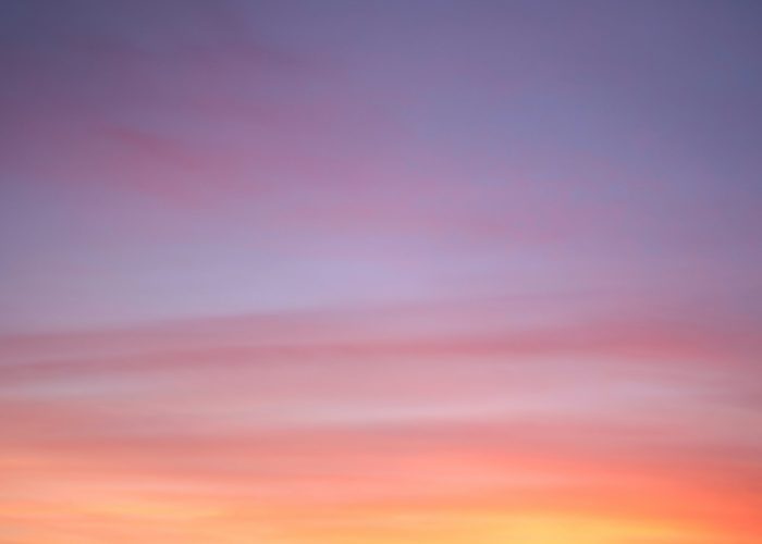 A tranquil sky at sunset, blending soft hues of pink, orange, and purple with gentle, wispy clouds.