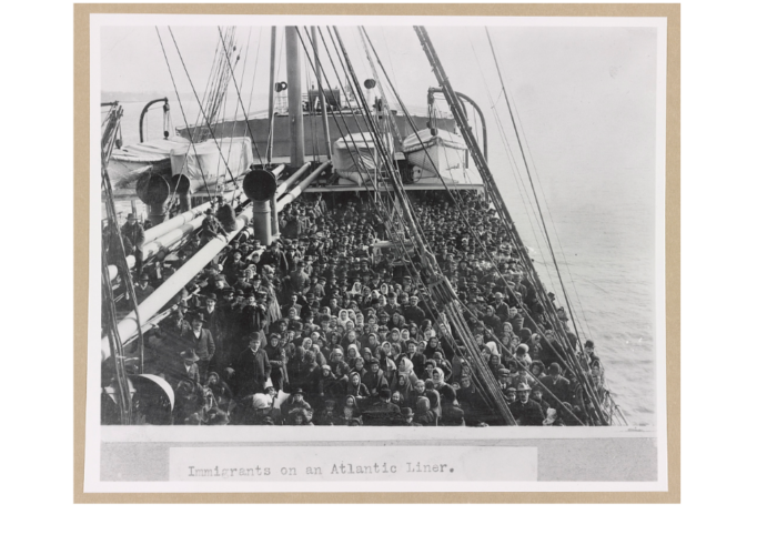 A crowded ship deck filled with immigrants crossing the Atlantic Ocean in the early 1900s.