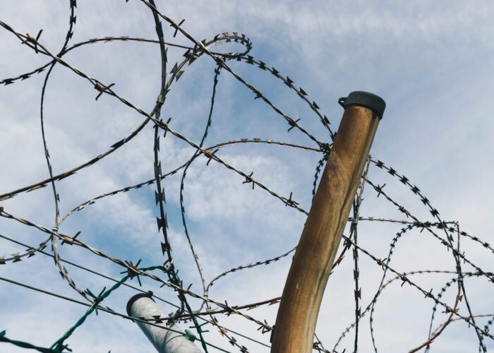 A barbed wire fence with a pole.