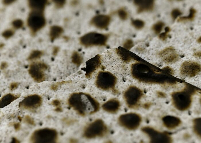 Close-up of pieces of matzah bread, showing its crisp, dotted, and slightly burnt surface.
