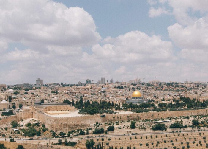 A panoramic view of the cityscape with a golden dome and historic buildings under a partly cloudy sky.