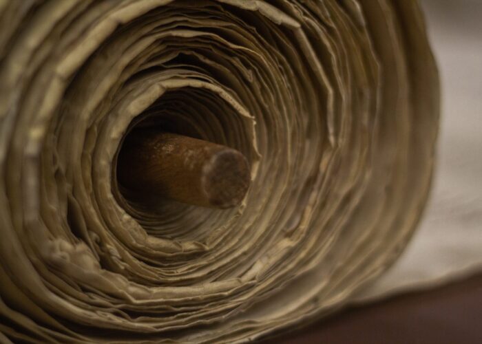 Close-up of a rolled parchment with a wooden rod in the center.